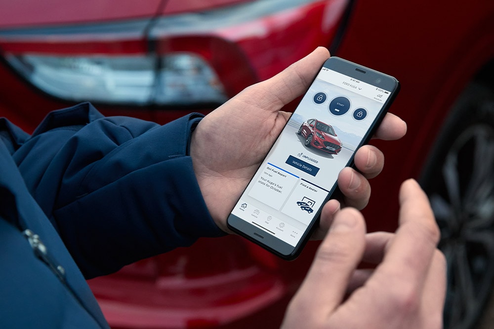 Persoon met smartphone toont FordApp-app met rode Ford Kuga.