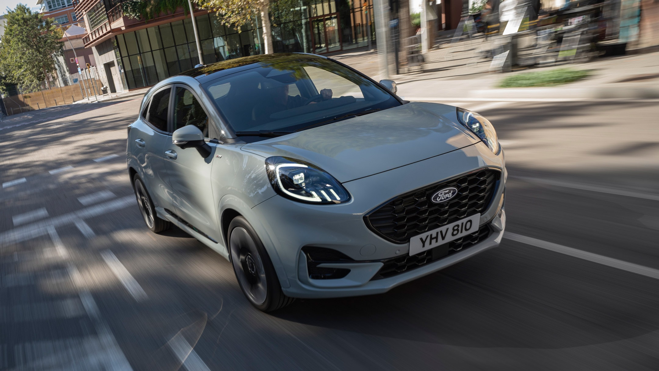 Een grijze Puma rijdt door de stad.