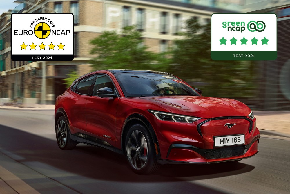 Een rode Mustang Mach-E rijdt over een weg, met daaroverheen de logo's van de NCAP-veiligheidsprijzen.