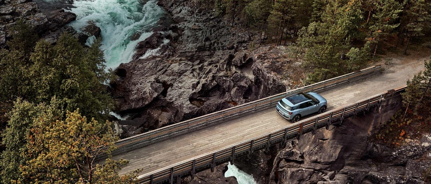 Le nouveau Ford Explorer, couleur bleu clair, vue aérienne, traversant un pont en bois étroit situé sur une rivière
