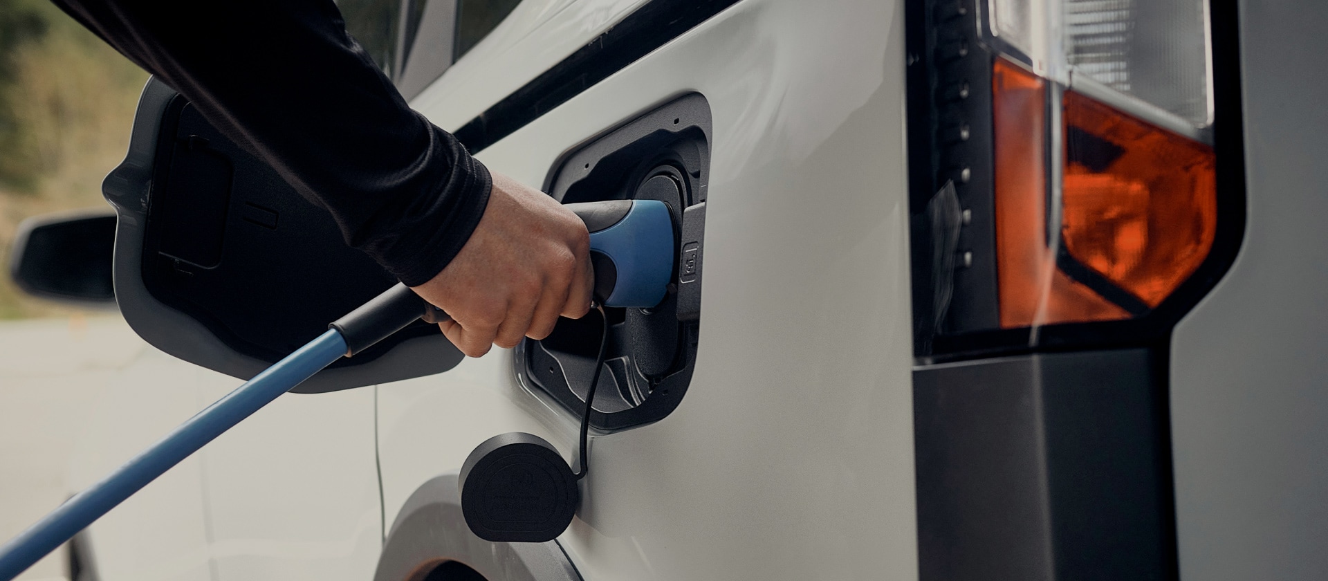 Close-up van een witte elektrische Ford die wordt aangesloten op een EV-oplader.