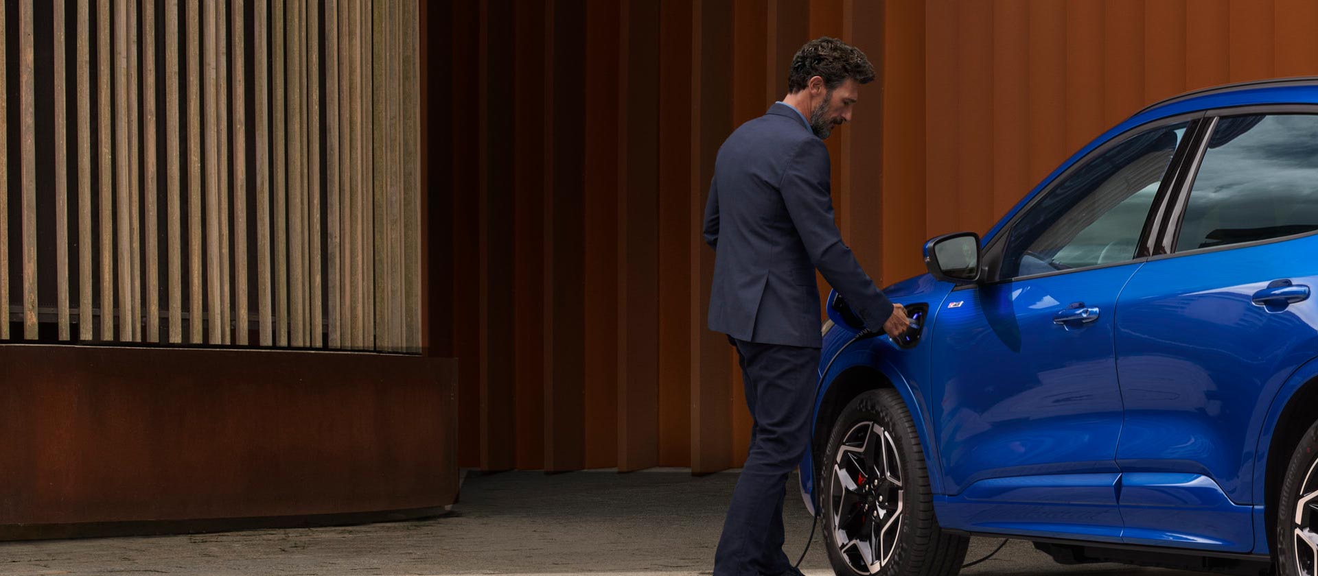 Een persoon die een Ford Plug-in Hybrid auto aansluit op een EV-thuislaadkabel.