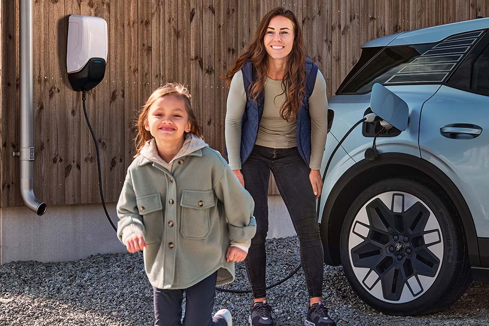 Een gezin dat plezier heeft terwijl ze hun elektrische Ford Explorer thuis opladen.