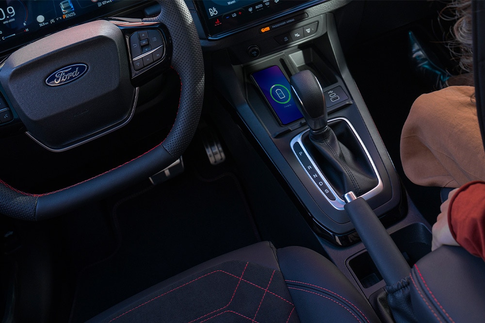 Een interieurzicht van een Ford Mild Hybrid auto, inclusief stuurwiel en automatische versnellingspook.