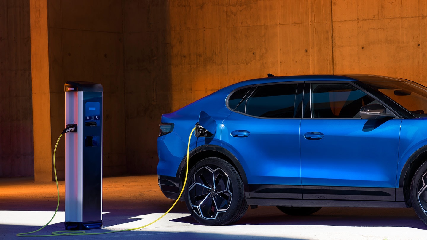 Een blauwe Ford Capri elektrische auto aangesloten op een EV-oplader.