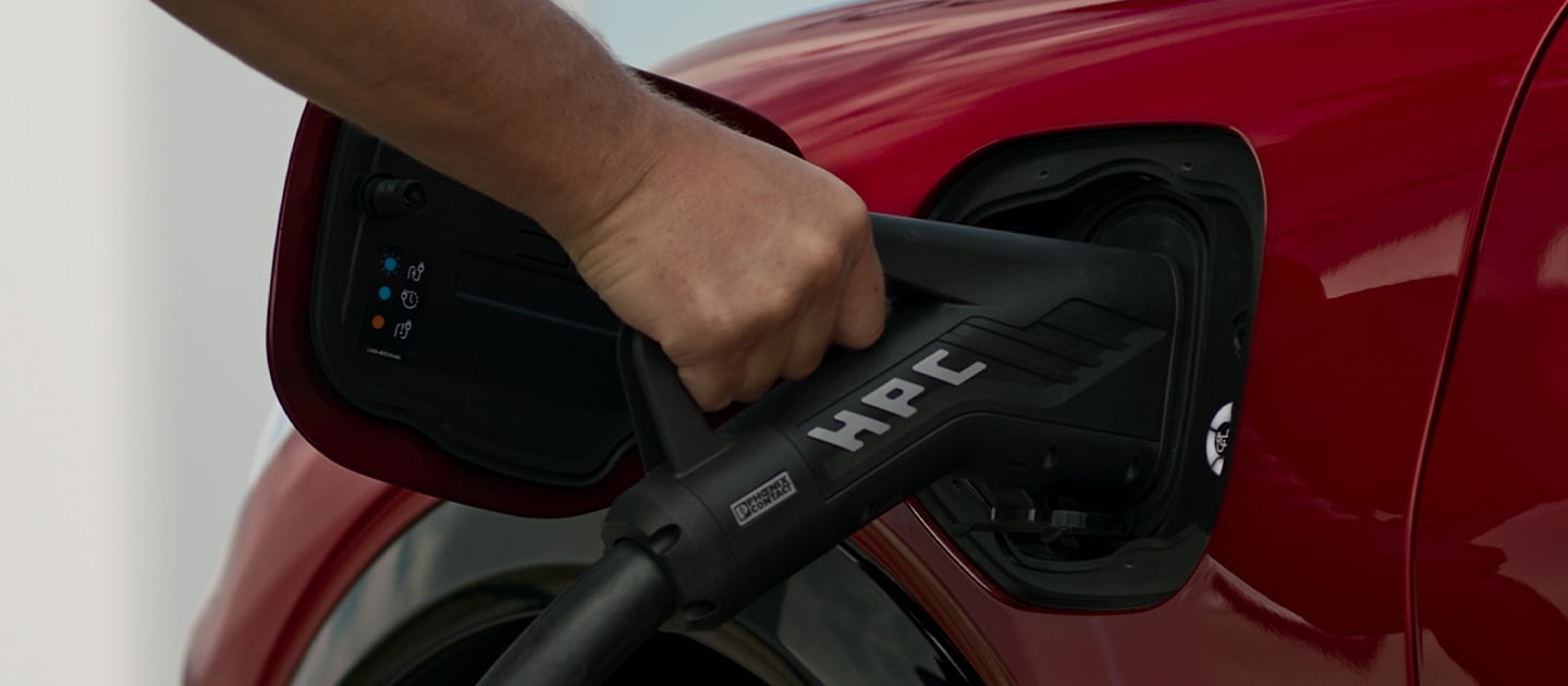 Close-up van een rode Ford EV die wordt aangesloten op een openbare HPC (High Power Charger) voor snel openbaar EV-laden.