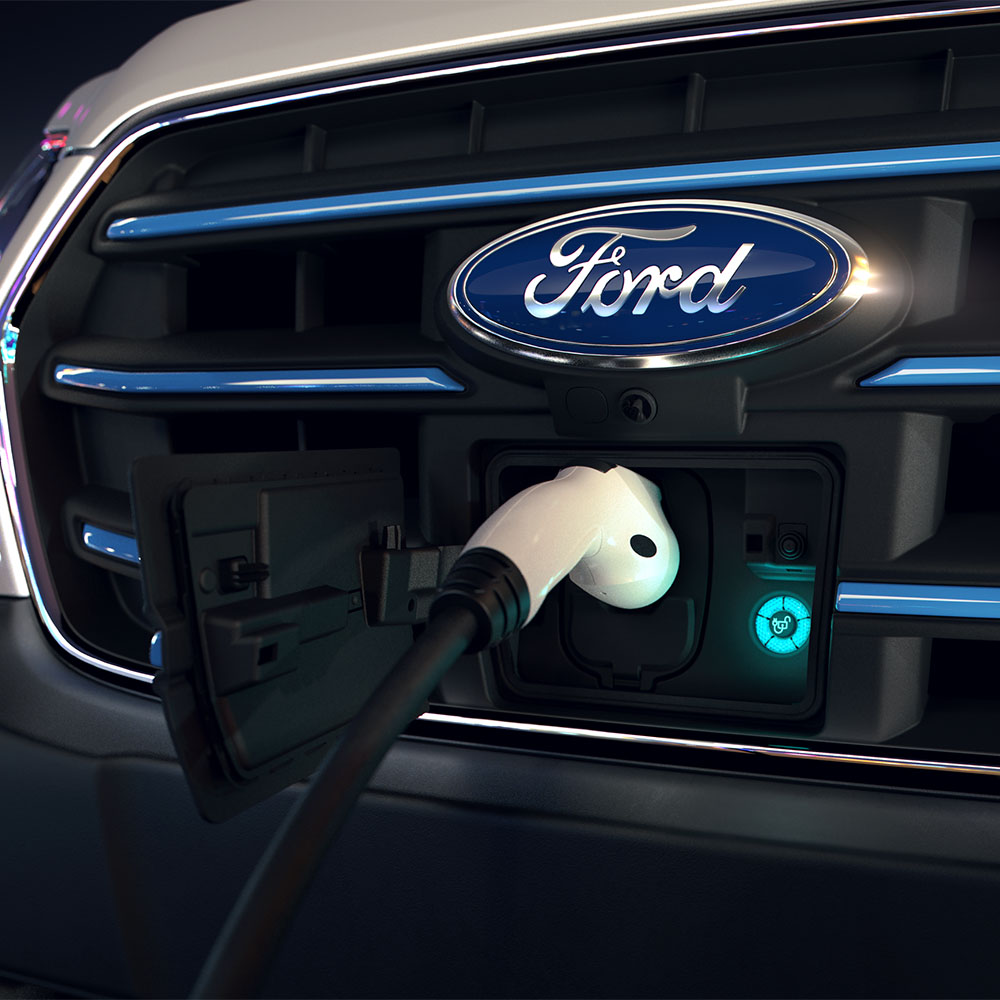 Close-up van een oplaadpunt van een Ford E-Transit bestelwagen en het blauwe ovale Ford-logo op de voorkant grille.