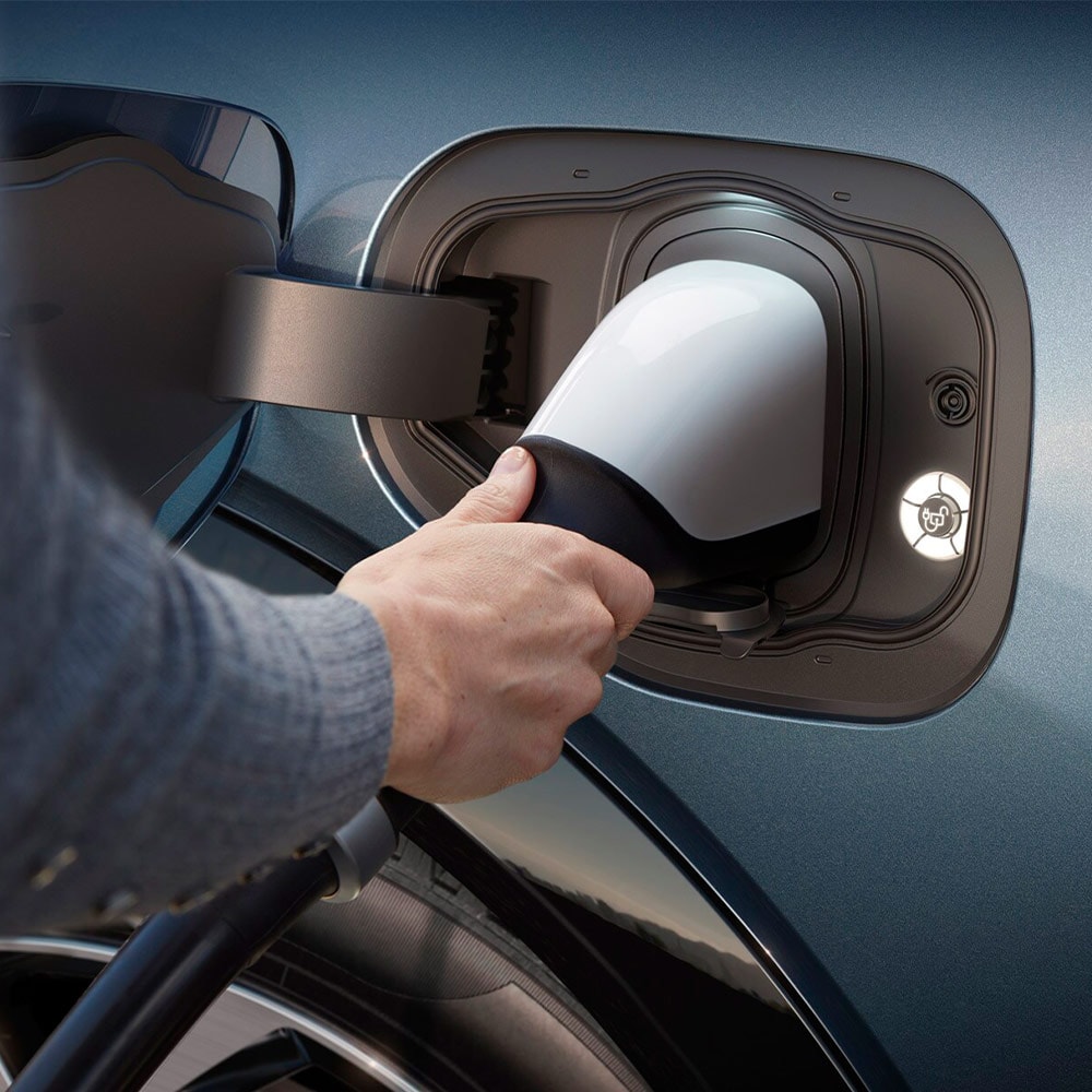 Een persoon die een ultrasnelle EV-lader aansluit op een elektrische Ford-voertuig.