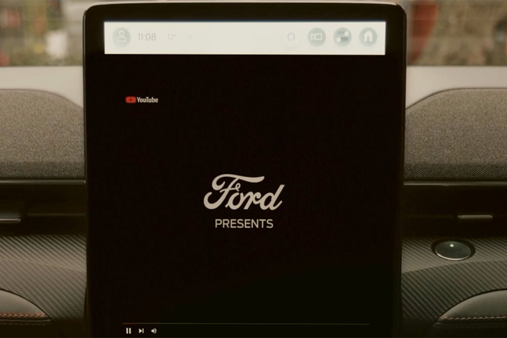 Een close-up van het 15.5" SYNC 4-touchscreen met een afbeelding met de tekst "Ford presents", om de videostreaming in de auto te tonen