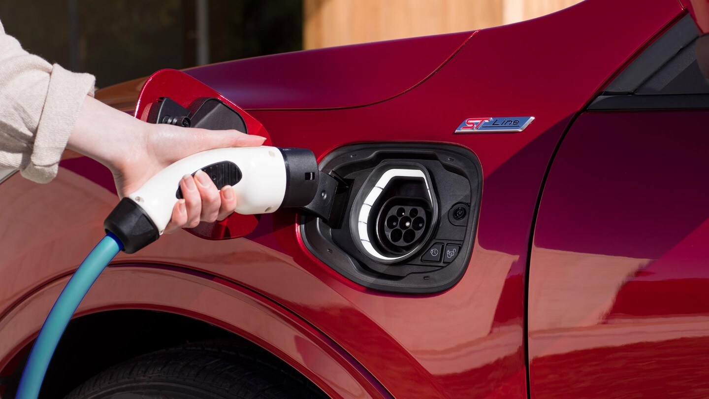 A woman charging a Ford Kuga Plug-In Hybrid