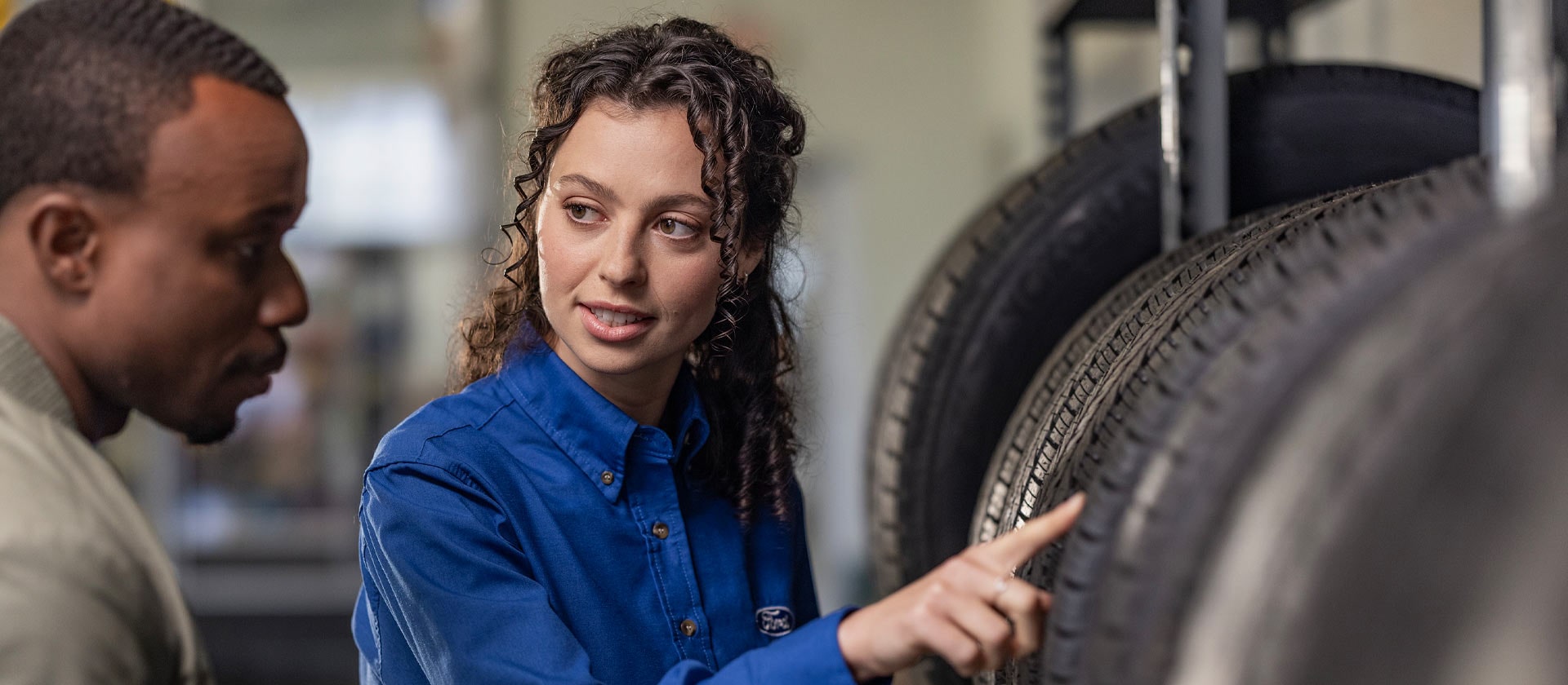 Een Ford reparatiespecialist helpt een klant met nieuwe Fiesta autobanden.
