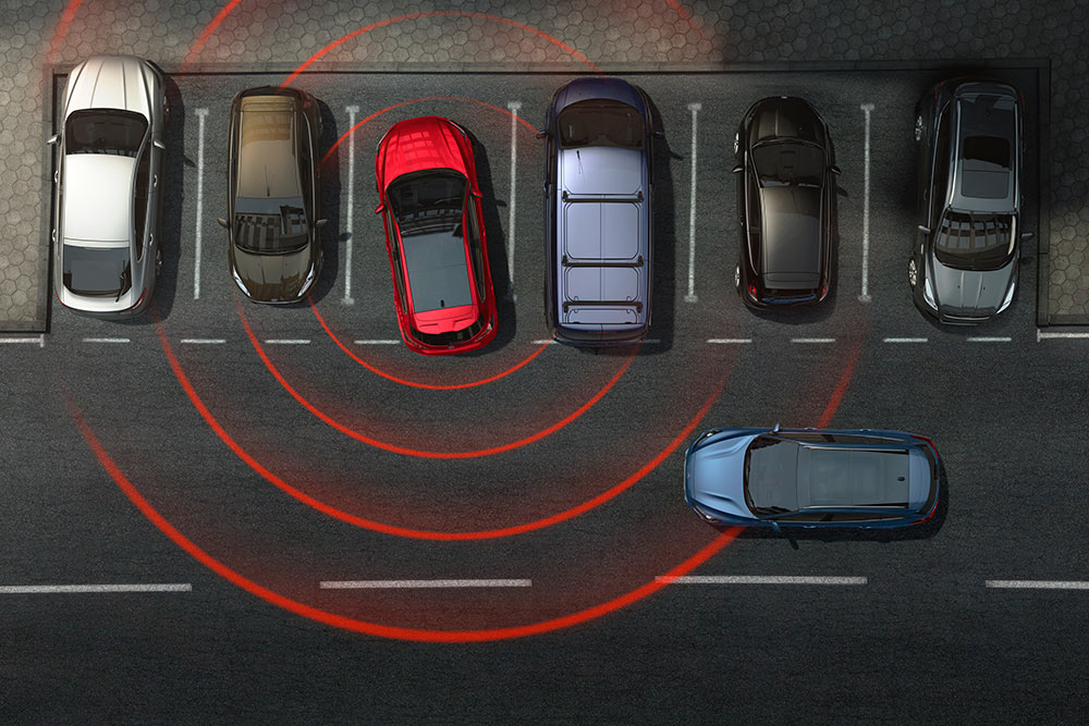 Afbeelding van een Ford-auto die achteruit uit een parkeerplaats rijdt, met actieve kruisend verkeerwaarschuwing.