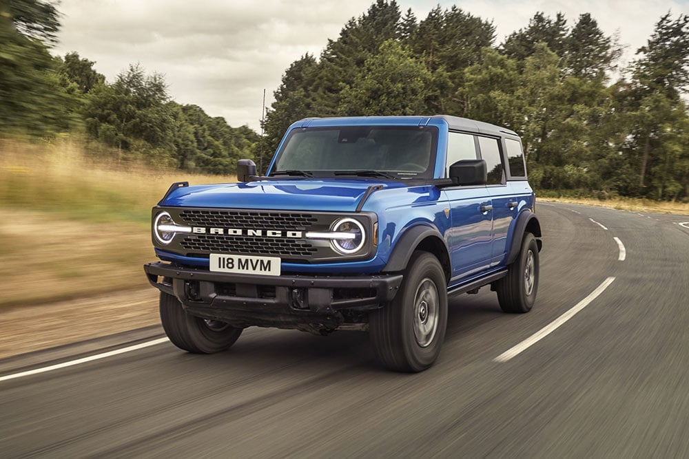 Vooraanzicht van de  Ford Bronco in blauw op een landweg.