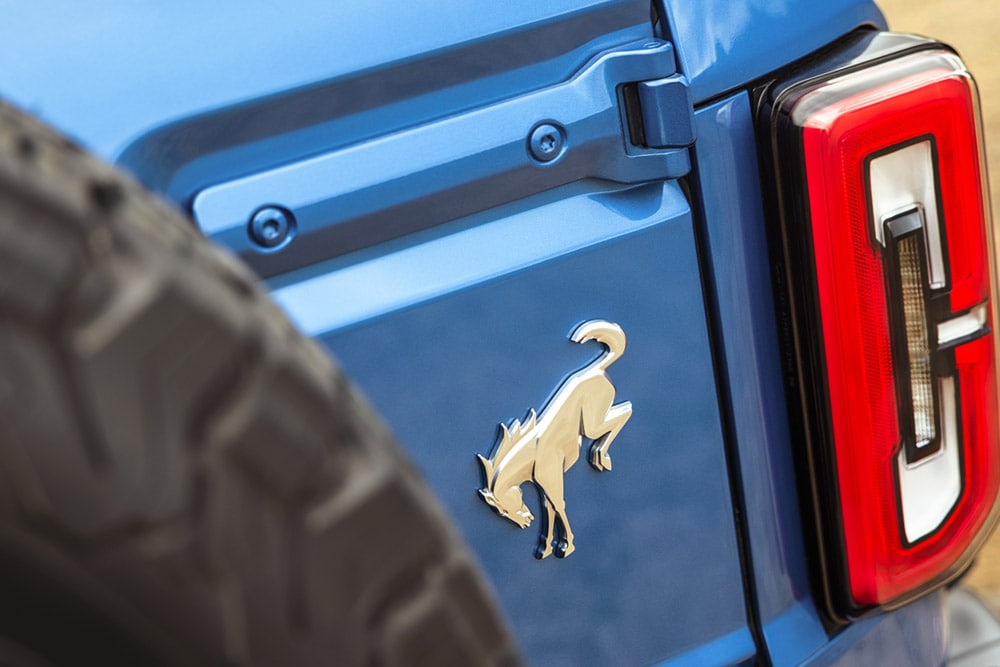 Een close-up van de merkdetails op de achterkant van een blauwe Ford Bronco.