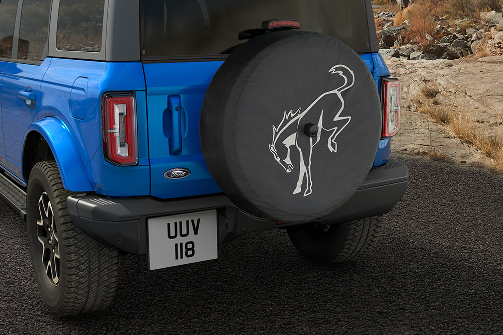 Achteraanzicht van een blauwe Ford Bronco met een reservewiel aan de achterkant.