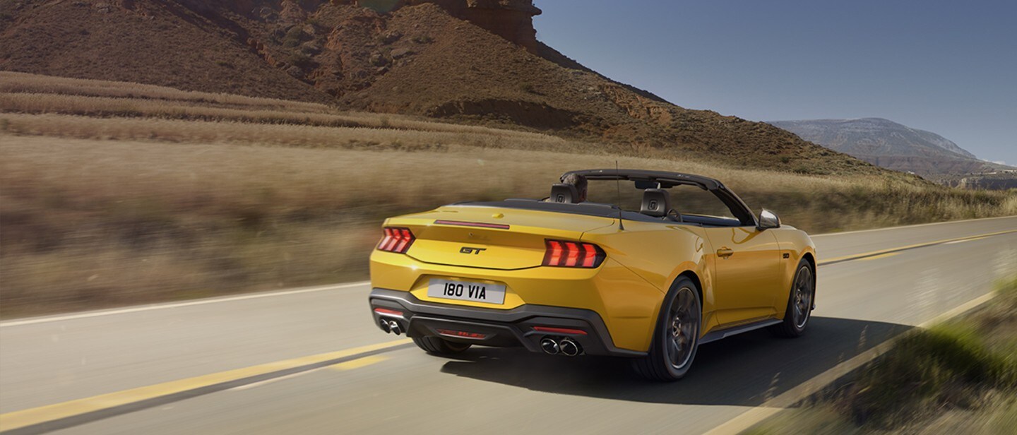 Yellow Mustang driving on the open road