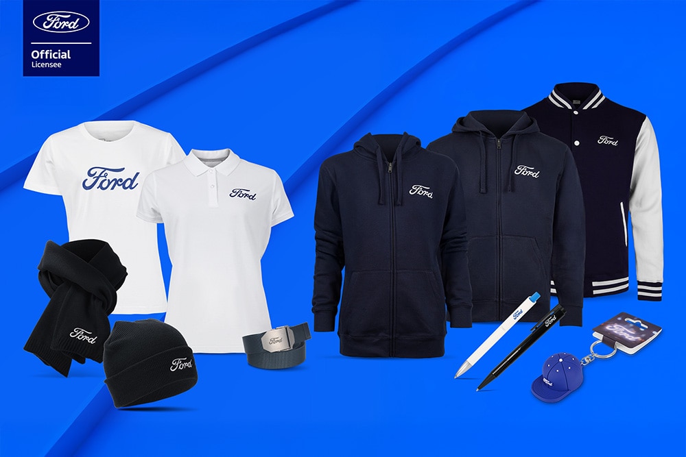 Ford merchandise collectie met diverse Ford voertuigen op de achtergrond, Ford paraplu, mokken en kledingstukken.