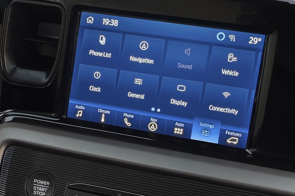 Het infotainmentscherm van de Ford Tourneo Courier toont menu-opties waaronder Telefoonlijst, Navigatie, Geluid, Voertuig en Connectiviteit.