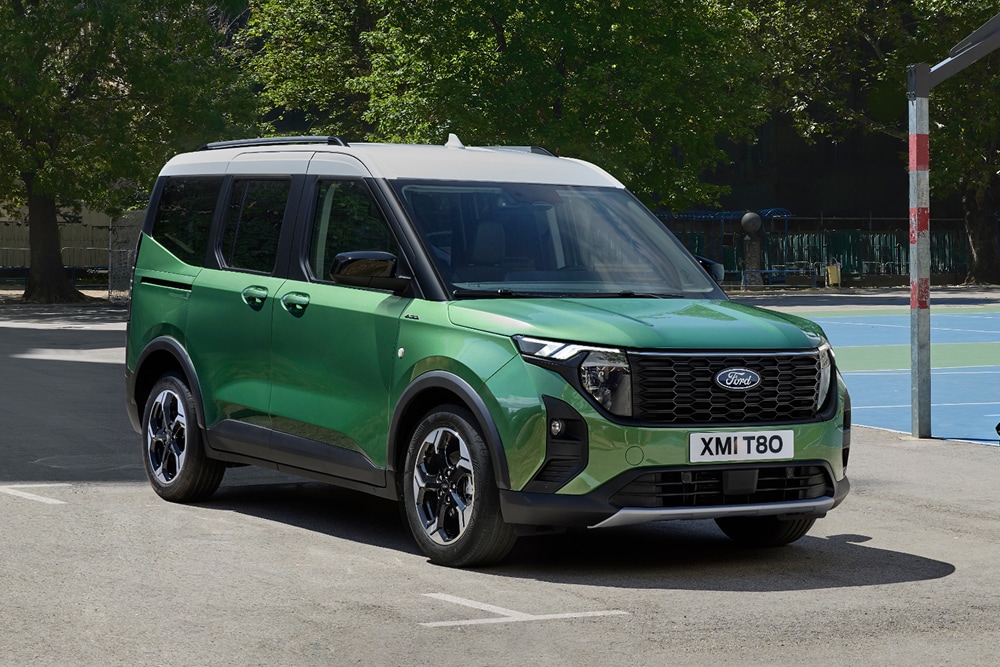 Een groene Ford Tourneo Courier geparkeerd op een basketbalveld, van voren schuin afgebeeld