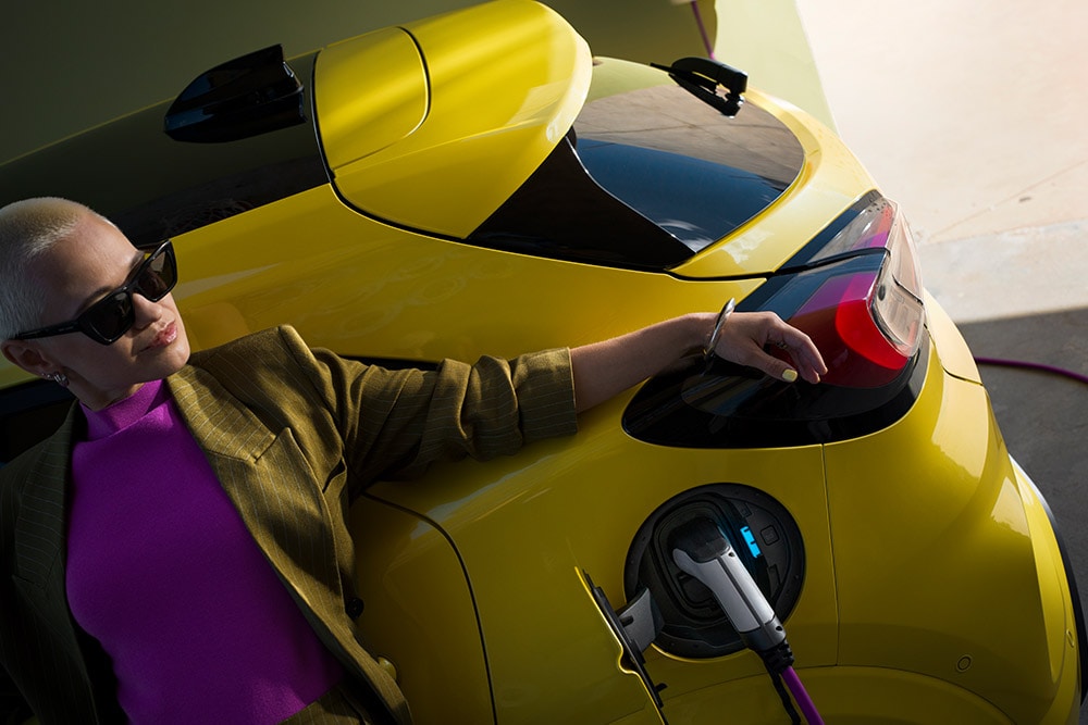 Een close-up van de achterkant van de elektrische Ford Puma Gen-E®, aangesloten op een wallbox voor thuisladen.
