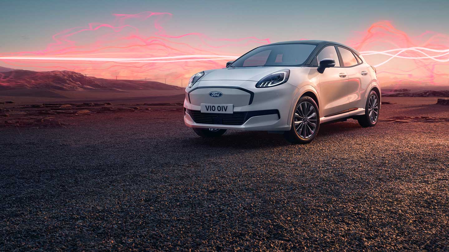 Het Ford Puma Gen-E Sound Edition-model in het wit, geparkeerd, met rode geluidsgolfafbeeldingen op de achtergrond.
