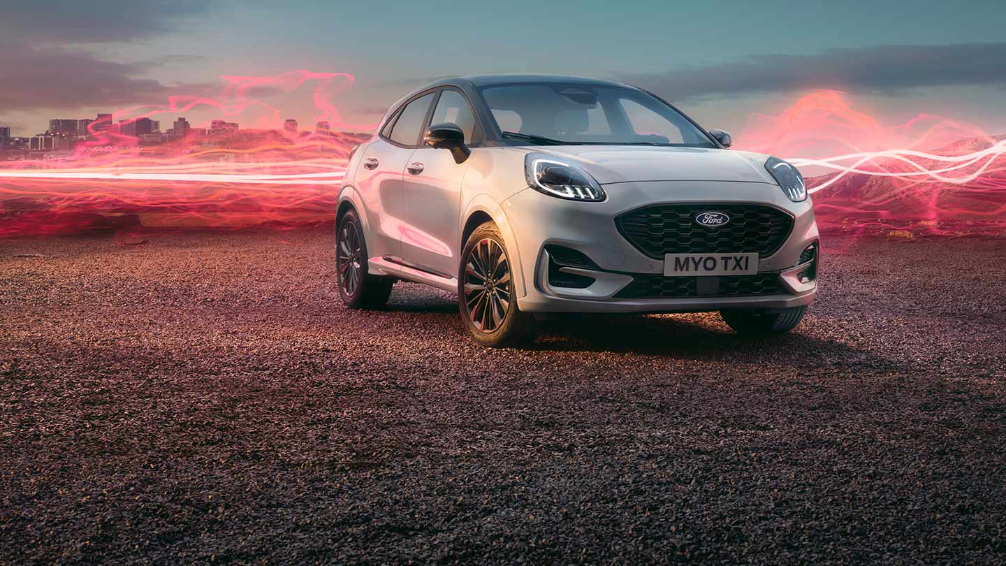 Het Ford Puma Sound Edition-model in het wit, geparkeerd met rode geluidsgolfafbeeldingen op de achtergrond.