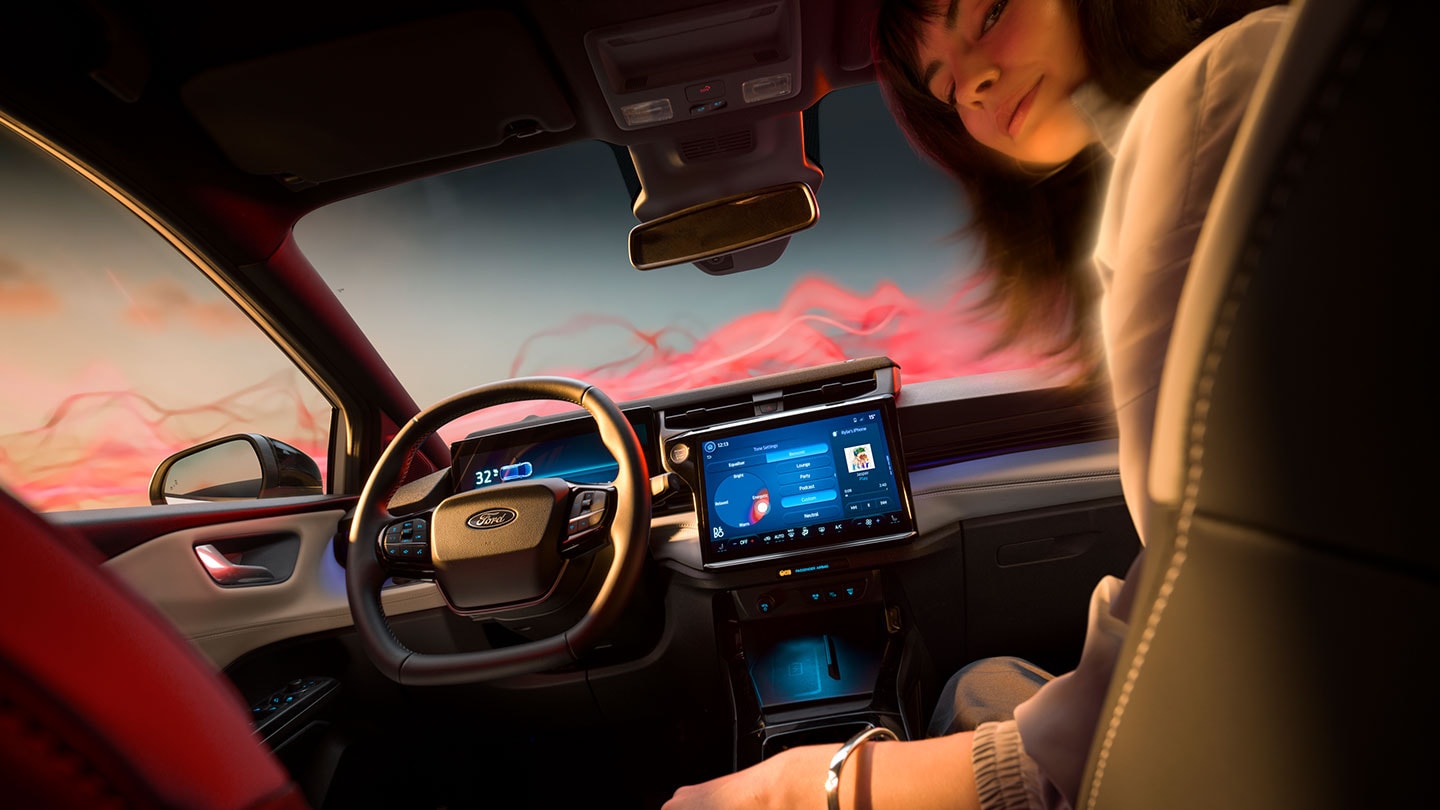 Het interieur van de Ford Puma Gen-E Sound Edition, met een vrouw op de passagiersstoel.
