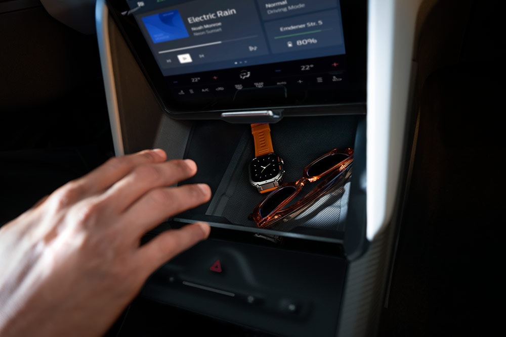 Een hand reikt naar de My Private Locker verborgen opslagsruimte in de Ford Capri®, met zicht op een horloge en een zonnebril binnenin.