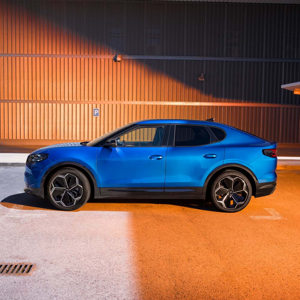 Een zijaanzicht van een blauwe Ford Capri. De 2024 Euro NCAP-veiligheidsscore met vijf sterren wordt weergegeven in de rechterbovenhoek.