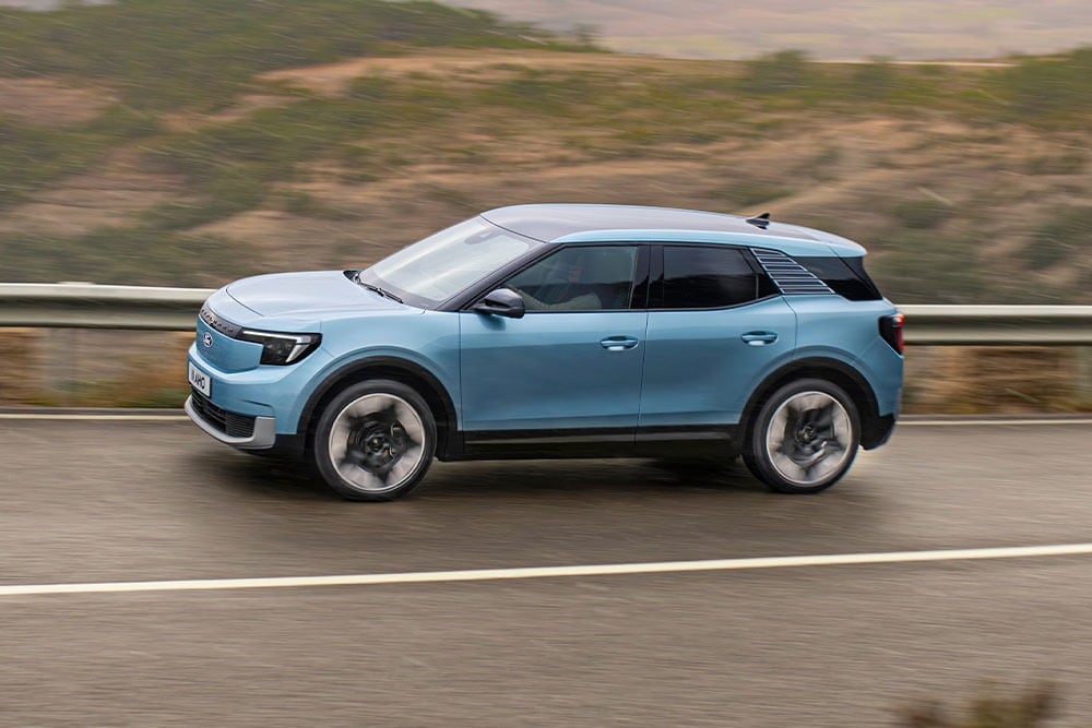 A blue Ford Explorer driving along a mountain road, with the 2024 five-star Euro NCAP logo on the top left corner.