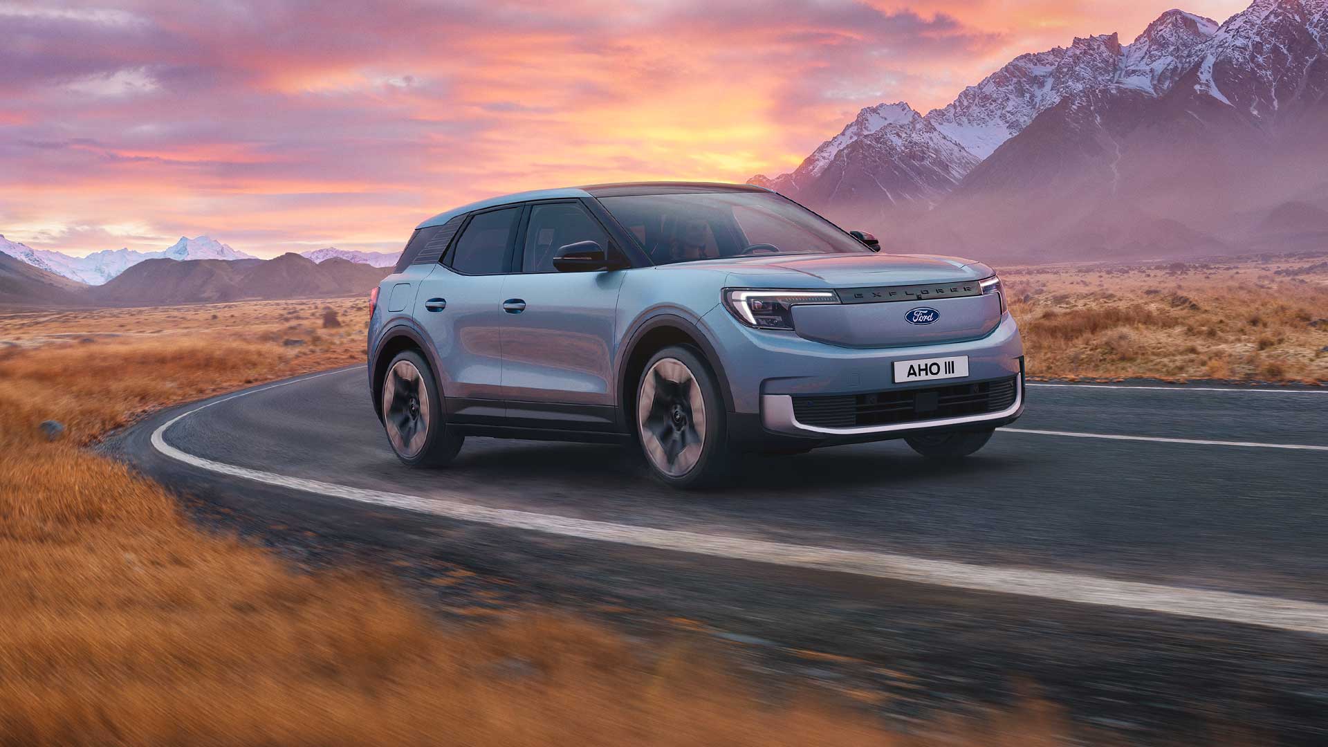 De nieuwe 100% elektrische Ford Explorer® rijdt bij zonsondergang over een bergweg.