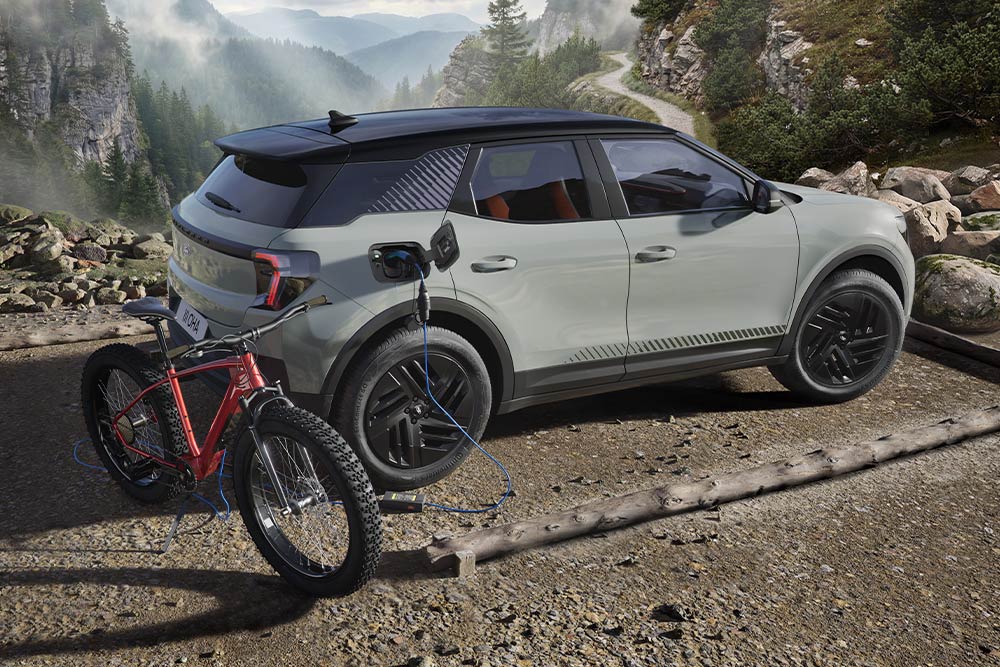 Achter zicht van een blauwe Ford Explorer die buiten wordt opgeladen, met een rode mountainbike ernaast.