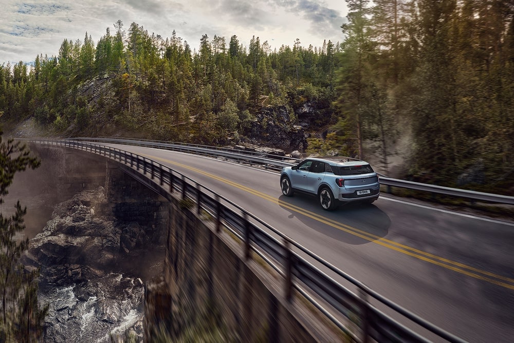 Een blauwe Ford Explorer SUV voor het gezin rijdt door een berglandschap.