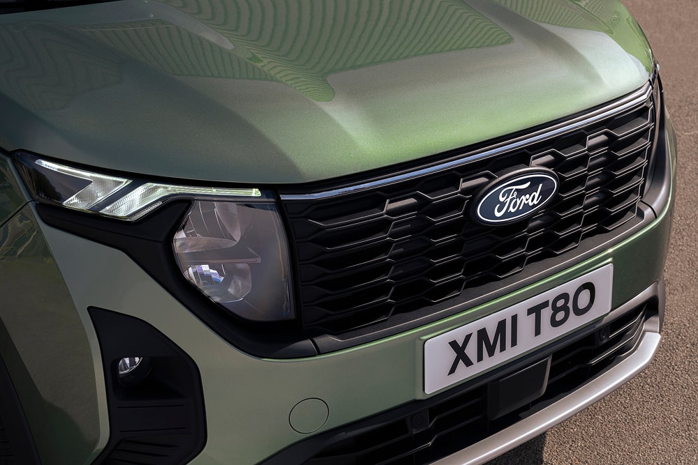 Voorgrille en koplampen van een groene Ford Tourneo Courier MPV.