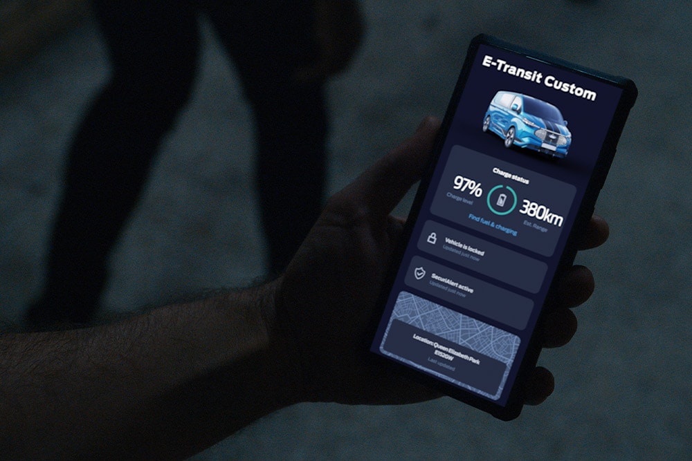 Smartphone met een E-Transit Custom in de FordPass-app, met de laadstatus en locatie van het voertuig.