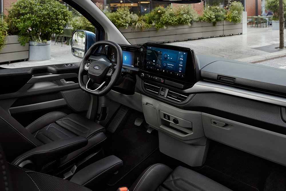 Het interieur van de Ford Tourneo Custom, met de bestuurderszetel, het dashboard en de middenconsole.