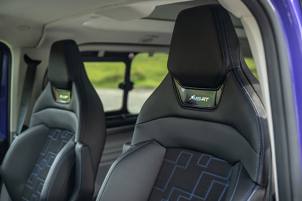 Voorzetels van zwart leer en suède met blauwe contrasterende stiksels en MS-RT-logo in een Ford Tourneo Custom MS-RT.