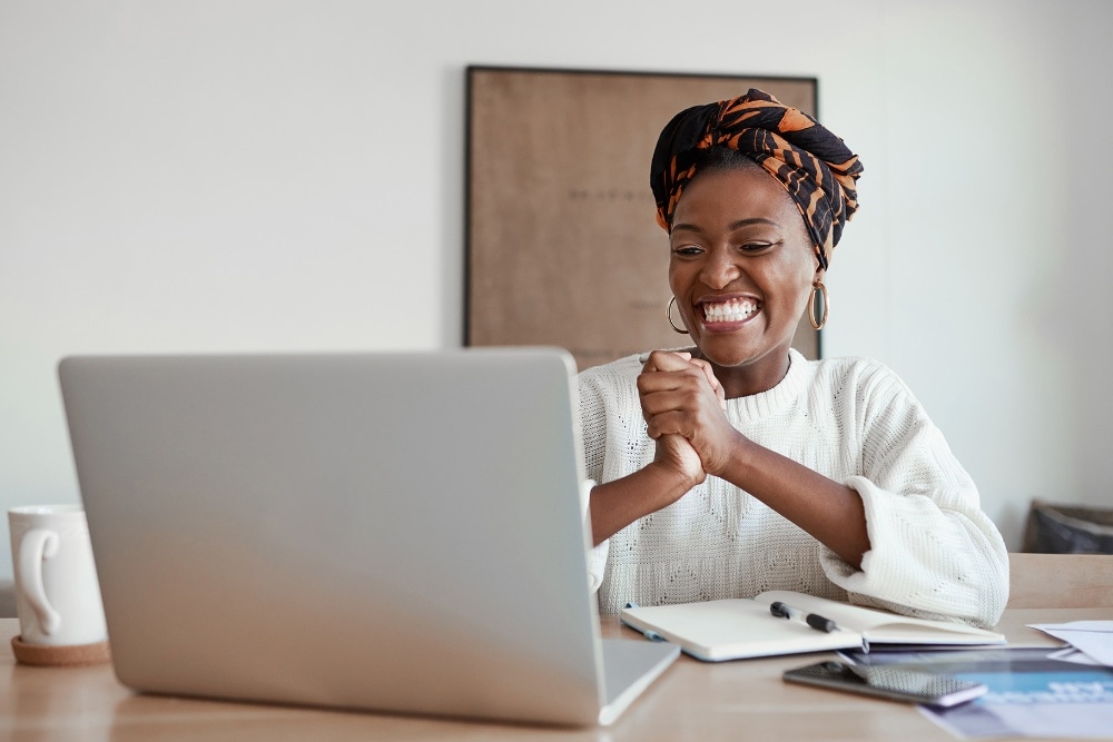 Vrouw lacht en kijkt naar laptop
