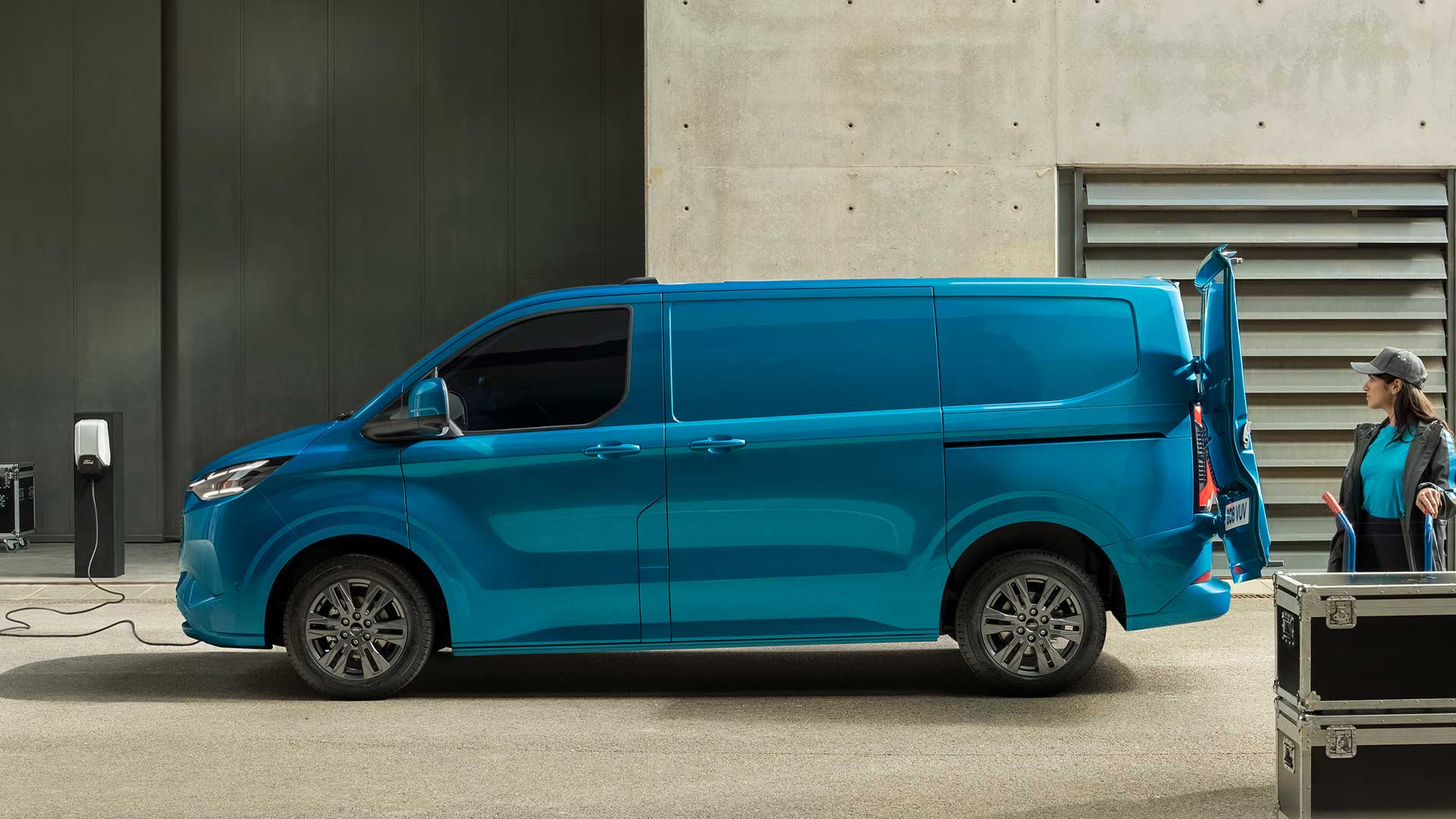 Blauwe Ford E-Transit Custom elektrische bestelwagen is aan het opladen.