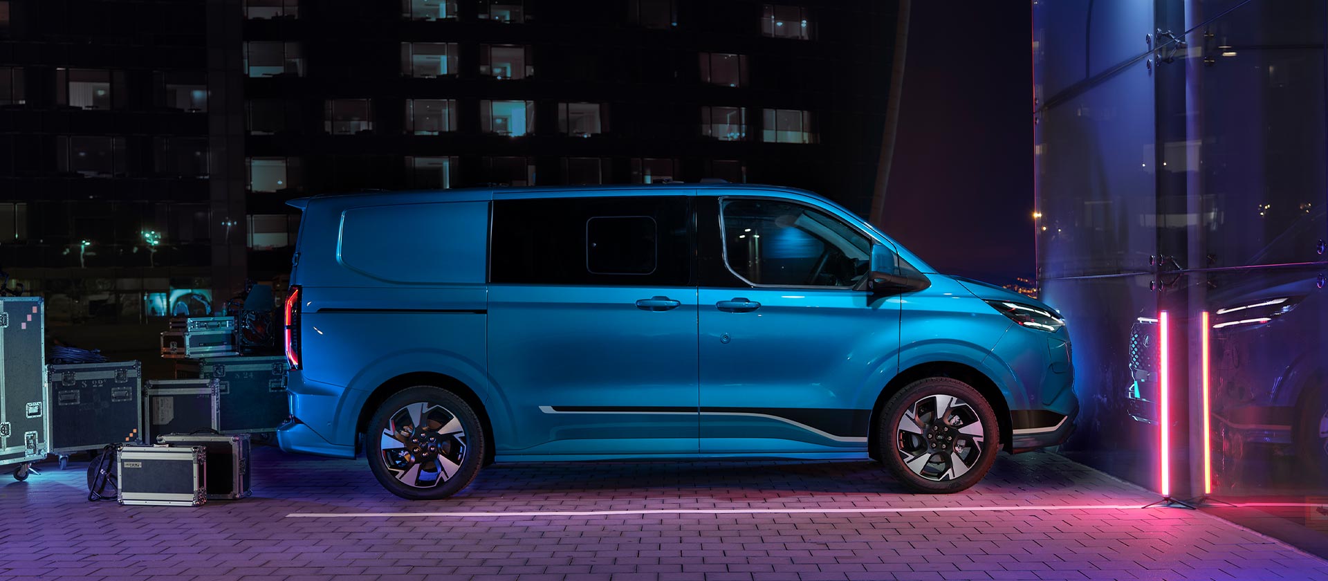 Blauwe Ford E-Transit Custom elektrische bestelwagen, zijaanzicht.