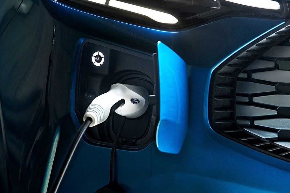Oplaadpoort van de blauwe Ford E-Transit Custom elektrische bestelwagen.