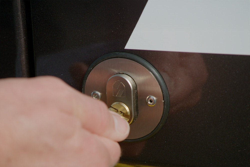 Hand die een deur van een bestelwagen vergrendelt met een sleutel.