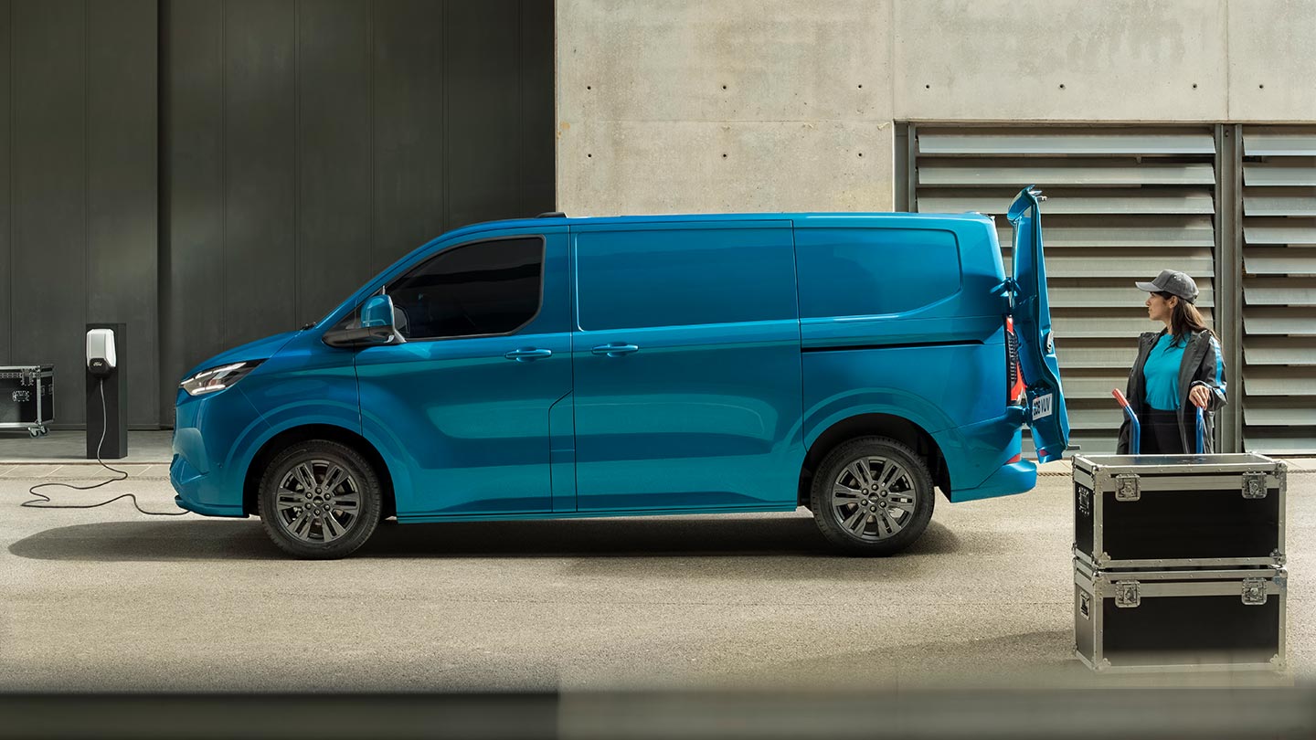 Blauwe Ford E-Transit Custom elektrische bestelwagen is aan het opladen.