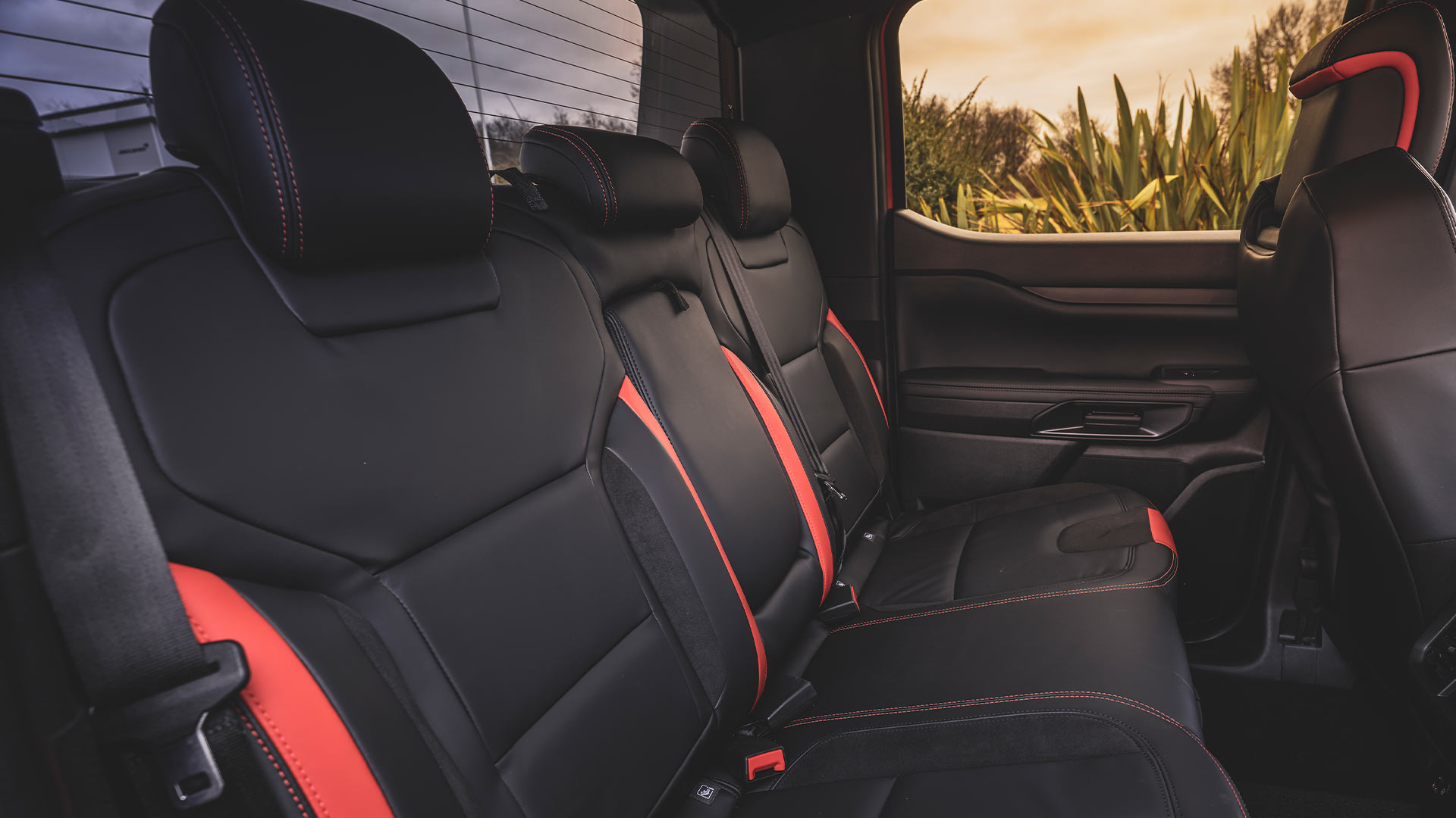 Achterzetels van de Ford Ranger Raptor, zwart met rode accenten.