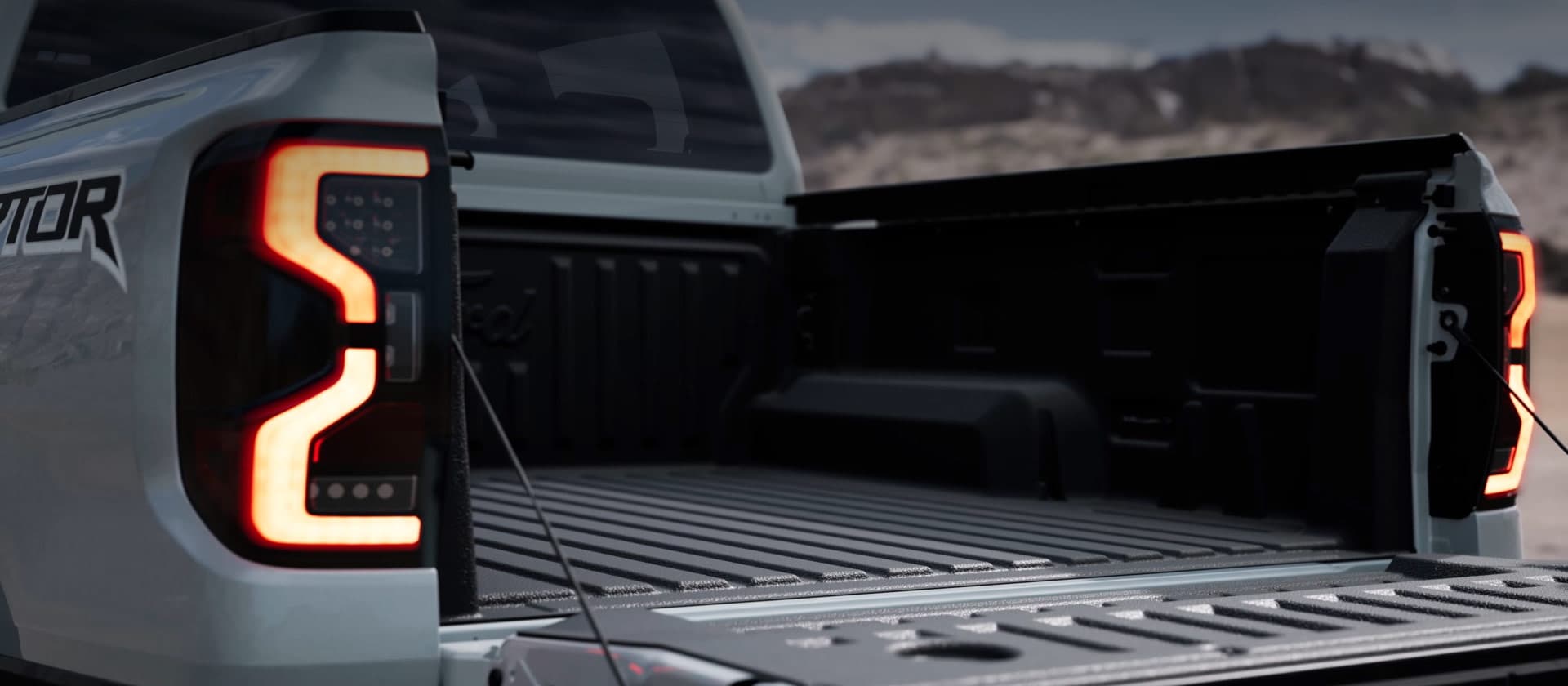 Zilveren Ford Ranger Raptor-laadbak met een open achterklep.