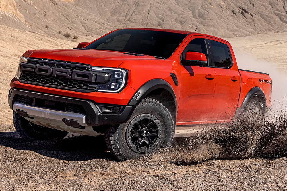 Ford Ranger Raptor in de kleur Code Orange rijdt in de modder.