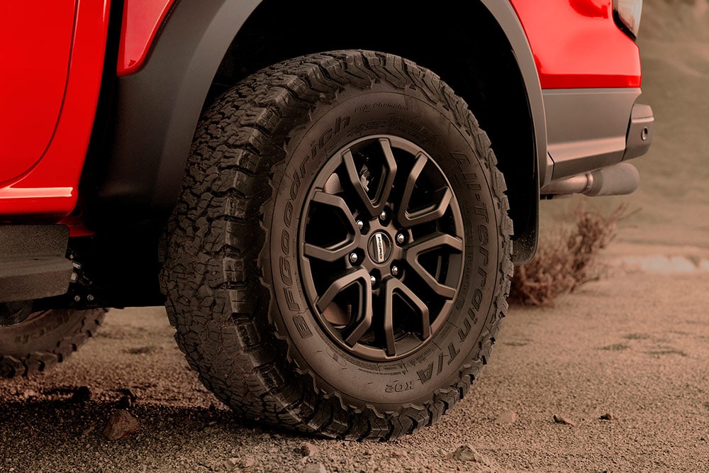 Detail van een band en velg van een Ford Ranger Raptor in de kleur Code Orange .
