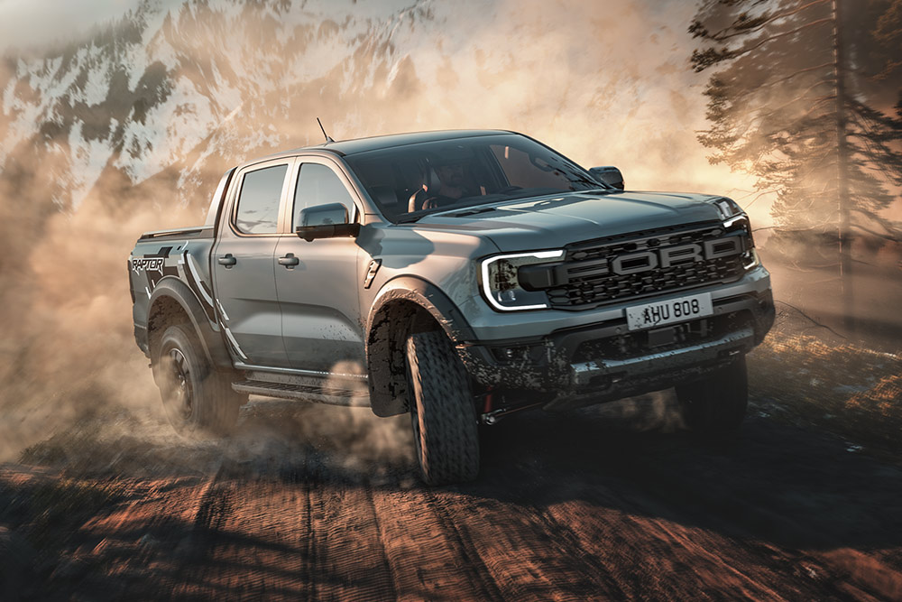 Een Ford Ranger Raptor rijdt in Baja over een onverharde weg door een bergachtig landschap.