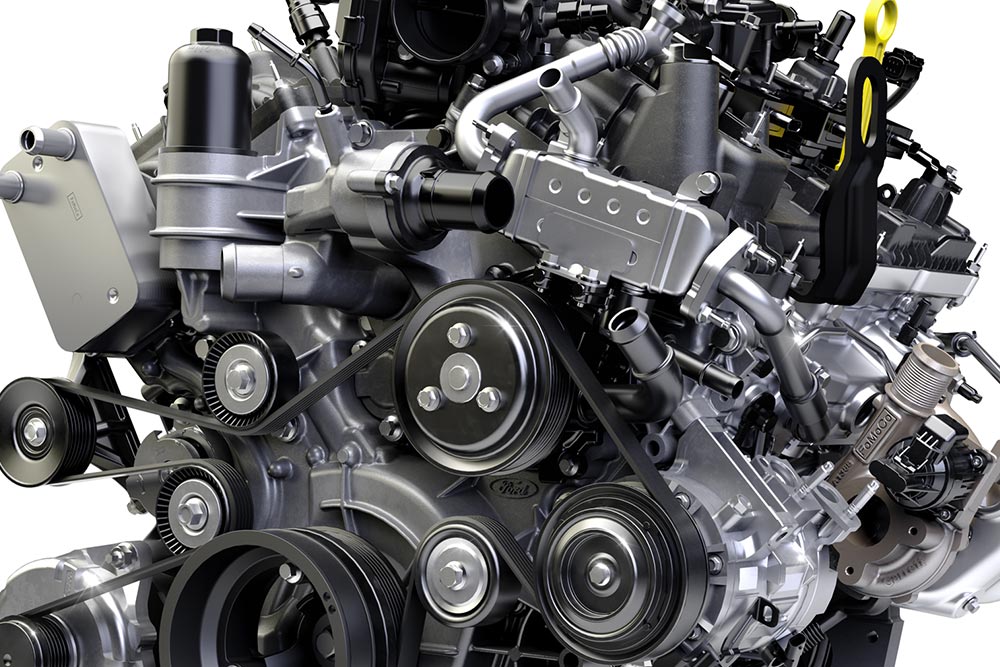 Een close-up van een automotor met meerdere riemen, riemschijven en mechanische onderdelen.