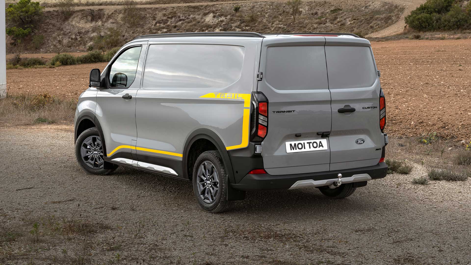 Achteraanzicht van een grijze Ford Transit Custom Trail bestelwagen.
